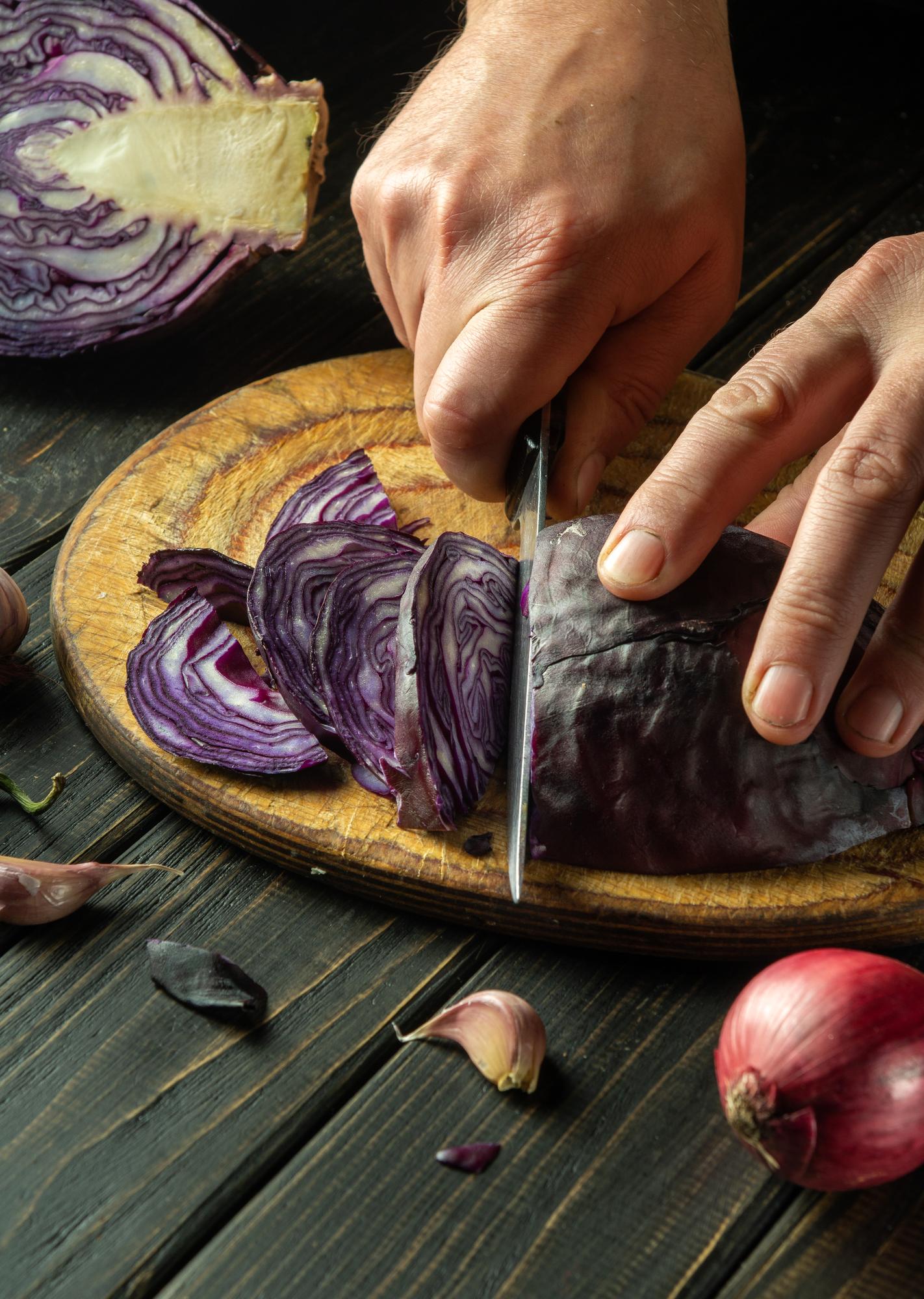 Dettaglio delle mani che affettano verdure con tecnica